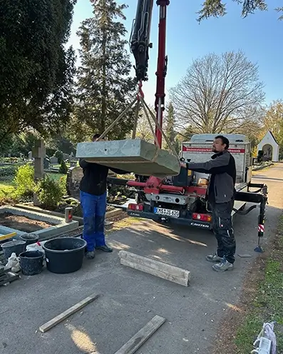 Die Firma Schwenk setzt einen neuen Grabstein auf dem Friedhof vom LKW ab